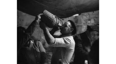 Imagem de um homem a beber do garrafão em Amieira dos Gatos, 1980.  Crédito: Nuno Félix da Costa.