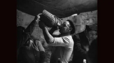 Imagem de um homem a beber do garrafão em Amieira dos Gatos, 1980.  Crédito: Nuno Félix da Costa.