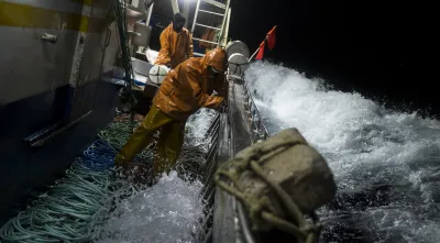 Pescadores indonésios a pescar durante a noite em Portugal, com grandes ondas a bater no barco.. Crédito: Daniel Rodrigues