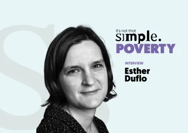 Retrato a preto e branco de Esther Duflo, prémio nobel de Economia, sobre um fundo azul claro e com o texto: "It's not that simple. Poverty. Interview Esther Duflo".