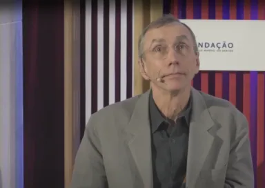 Svante Pääbo a discursar num evento da Fundação. Ao fundo, o logotipo da Fundação.