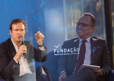 Imagem de duas fotografias sobrepostas: do lado direito o entrevistador, do lado esquerdo, o entrevistado. Ao centro, o logotipo da Fundação.