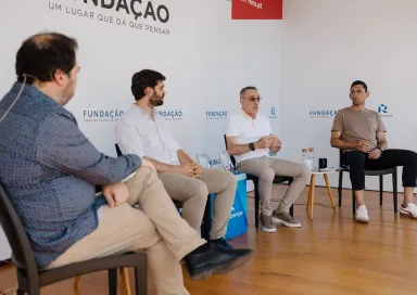 Quatro homens sentados num palco, em cadeiras pretas, entre eles o ex-selecionador e treinador Paulo Bento.