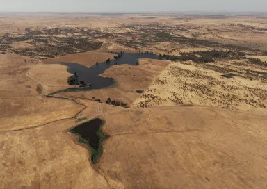 Imagem aérea de vários terrenos áridod r algumas manchas de água.