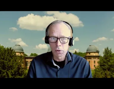O perito em Sustentabilidade Johan Rockström de fones, numa videoconferência, com um fundo de um observatório e céu azul com nuvens.