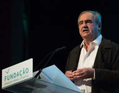 Pierre Rosanvalon a falar, em palco, com o logotipo "Fundação" em destaque no púlpito.