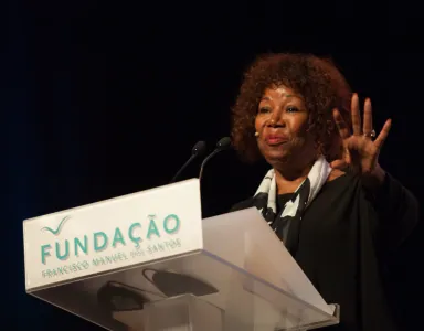 Ruby Bridges a gesticular, enquanto fala num púlpito que tem destacado o texto "Fundação Francisco Manuel dos Santos".