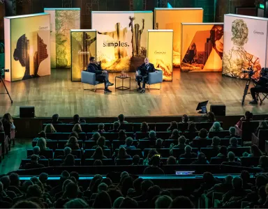 Plateia sentada a olhar para o palco, onde está o historiador Simon Sebag Montefiore a ser entrevistado, na Aula Magna.