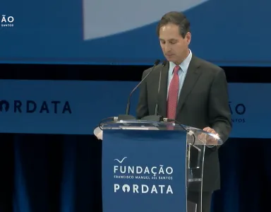 O demógrafo David Bloom a discursar num púlpito com o logotipo da Fundação e da Pordata.