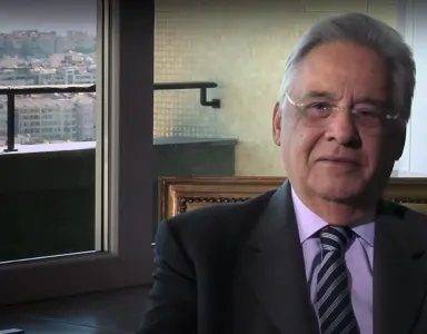 O antigo presidente do Brasil, Fernando Henrique, sentado. Ao fundo, uma janela com vista para a cidade.