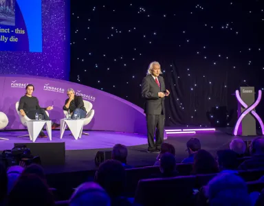 Michio Kaku num palco a discursar, de fato, para uma plateia. 