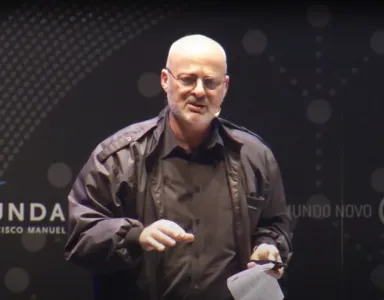 O investigador Evgeny Morozov a discursar, em palco, com uma folha nas mãos. 
