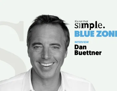 Retrato a preto e branco de Dan Buettner, com texto "BLUE ZONES" ao lado.