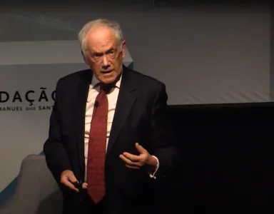 Peter Atkins a falar no palco do Auditório Mar da Palha do Oceanário de Lisboa, com o texto no fundo "Fundação Francisco Manuel dos Santos"
