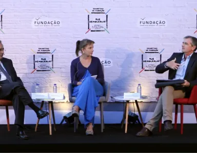 Catherine Moury, com António Goucha Soares e António Araújo sentados. Ao fundo, um painel com o logotipo da Fundação e o texto "Que Democracia?".