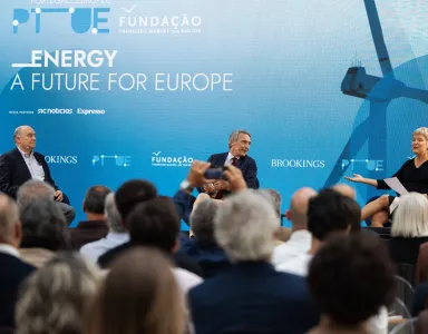 Três pessoas sentadas no palco. Uma plateia a assistir. Texto "Energy, a future for Europe".