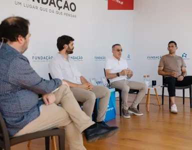 Quatro homens sentados num palco, em cadeiras pretas, entre eles o ex-selecionador e treinador Paulo Bento.
