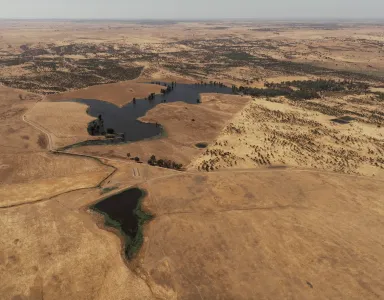 Imagem aérea de vários terrenos áridod r algumas manchas de água.