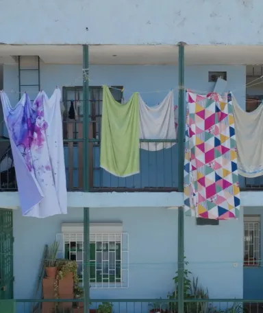 Imagem de roupa estendida a secar ao sol num bairro pobre