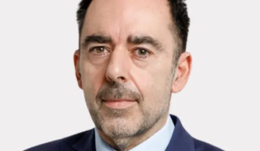 Retrato do comentador desportivo Carlos Freitas sobre um fundo cinza claro.