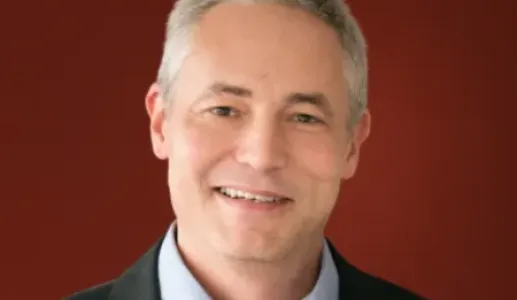 Retrato de Keith Johnson, autor da revists internacional Foreign Policy, sobre um fundo vermelho escuro.