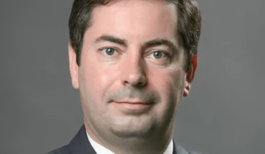 Retrato de Luís Rebelo, especialista em transição energética, num fundo cinzento escuro.