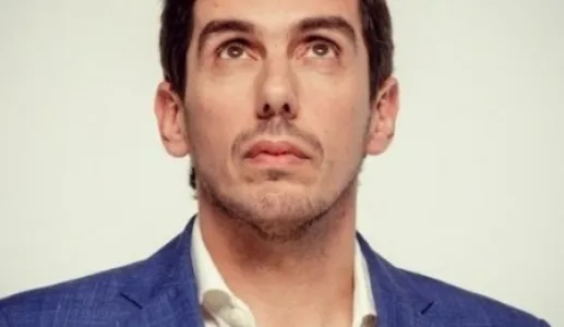 Retrado do humorista Cláudio Almeida a olhar para cima.