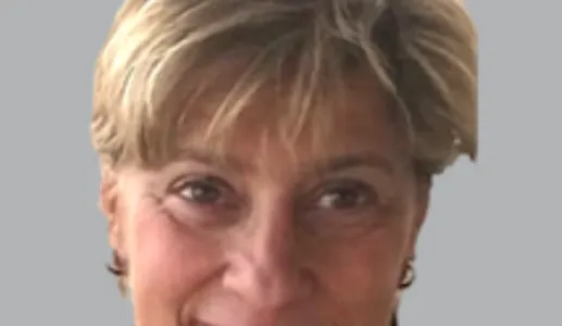 Retrato a cores da economista Isabel Grilo. Fundo cinzento.