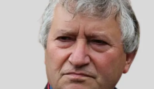 Retrato a cores de um homem, o arqueólogo António Martinho Baptista, com o cabelo grisalho.