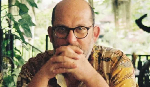 Retrato de um homem, vestido com uma camisa com desenhos. 