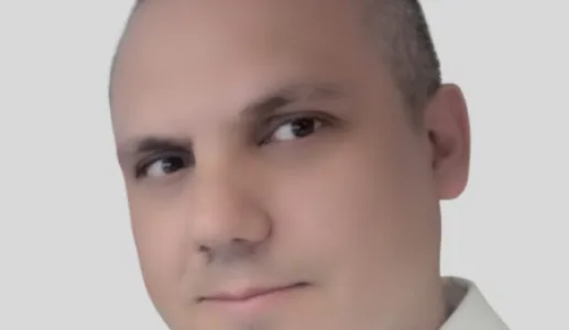Retrato a cores de um homem, vestido com uma camisa branca. Fundo claro.