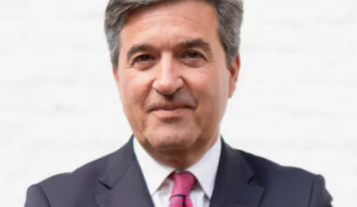 Retrato a cores de um homem, vestido com um fato preto e com uma gravata rosa com quadrados azuis. D/R