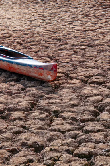 Imagem de uma canoa numa barragem seca, que ilustra o impacto da seca atual na barragem de Sau, na Catalunha. Créditos: shutterstock