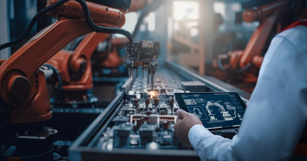 Imagem de um engenheiro a controlar um robô numa fábrica