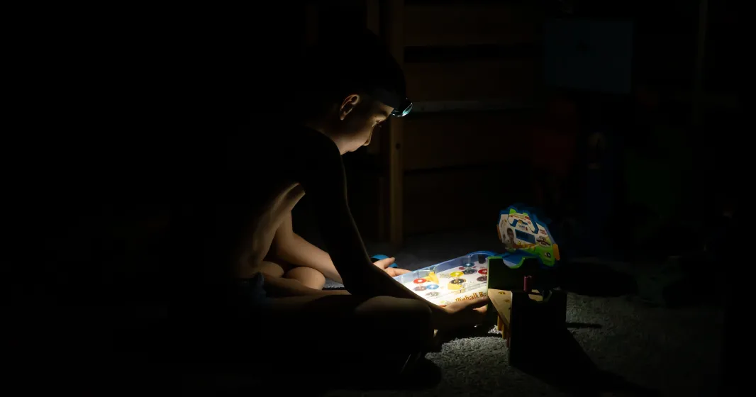 Imagem de um menino a brincar, às escuras; durante um apagão em Kiyv, na Ucrânia. Créditos: shutterstock