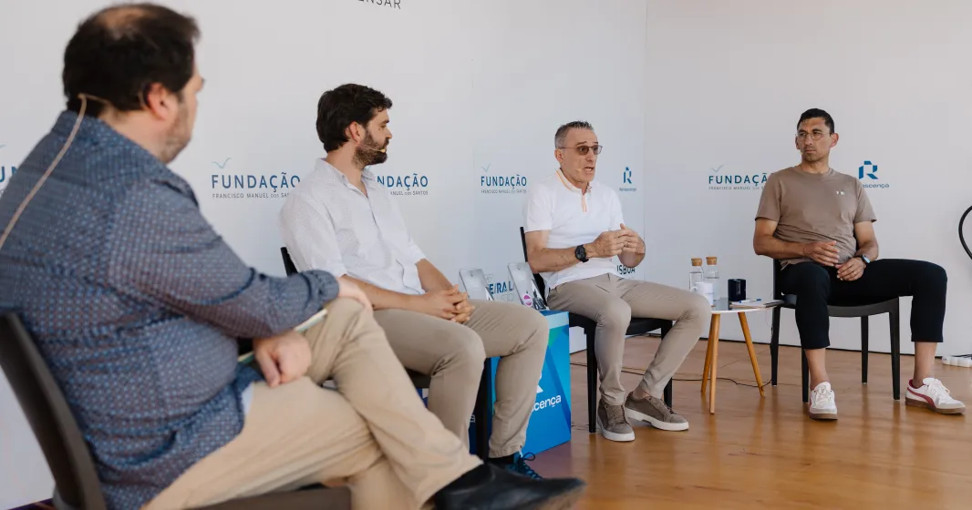 Quatro homens sentados num palco, em cadeiras pretas, entre eles o ex-selecionador e treinador Paulo Bento.