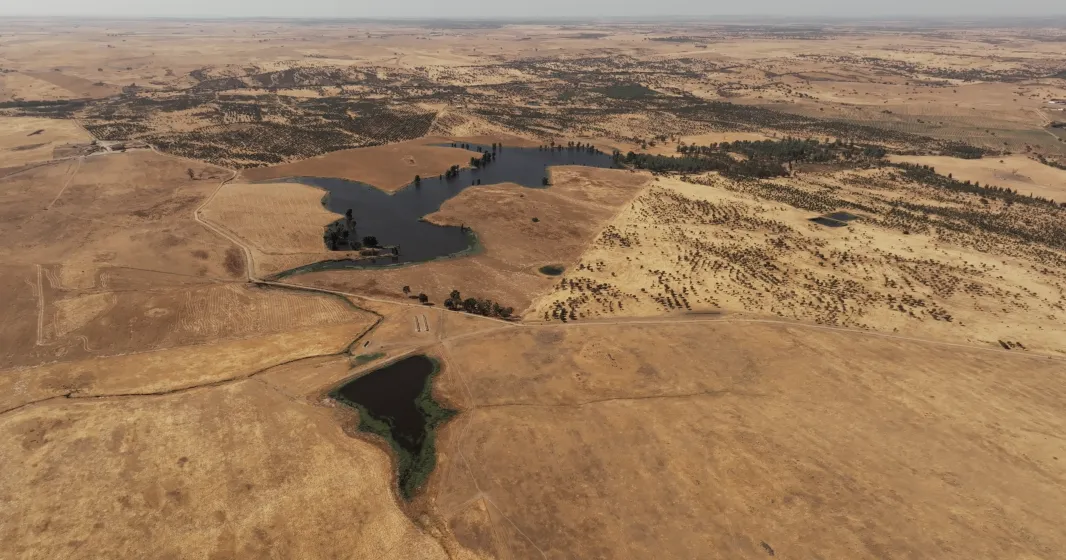 Imagem aérea de vários terrenos áridod r algumas manchas de água.