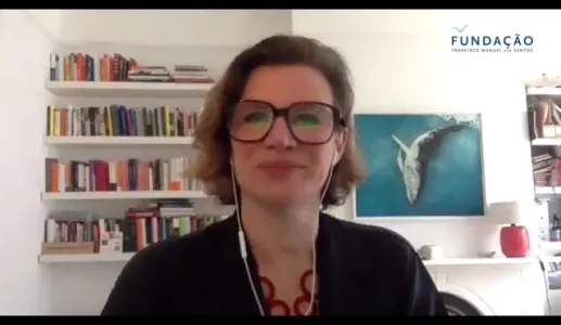 A economista Mariana Mazzucato sobre um fundo com estantes de livros e um quadro de uma baleia.