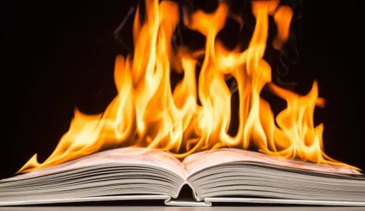 Livro aberto com chamas intensas em cima das páginas.