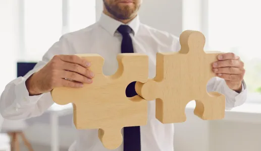 Imagem de um empresário a juntar as peças de um puzzle