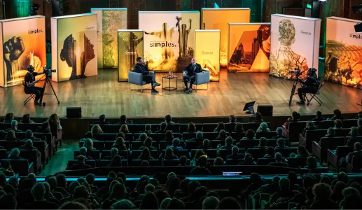 Plateia sentada a olhar para o palco, onde está o historiador Simon Sebag Montefiore a ser entrevistado, na Aula Magna.