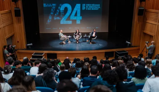 Imagem do auditório da Escola Secundária de Camões, em Lisboa, com Hugo van der Ding a moderar a conversa entre os alunos, Mónica Vieira, e o economista Pedro Freitas