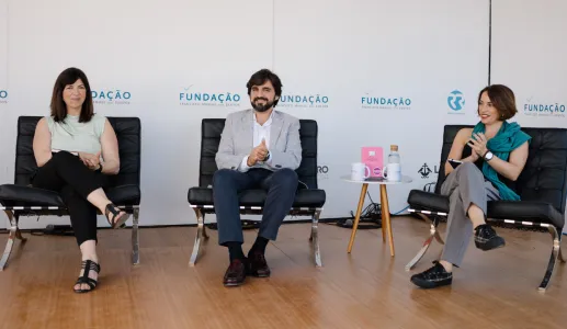 Três pessoas sentadas em cadeiras, aplaudindo, com logotipos da FUNDAÇÃO ao fundo.