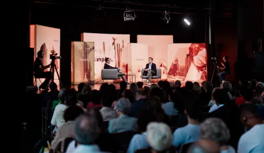 Evento com público sentado, e Peter Frankopan, em palco, a ser entrevistado por um jornalista. 