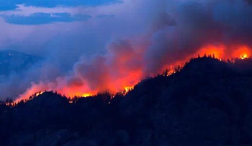 Imagem de uma serra em chamas, recortada no horizonte.