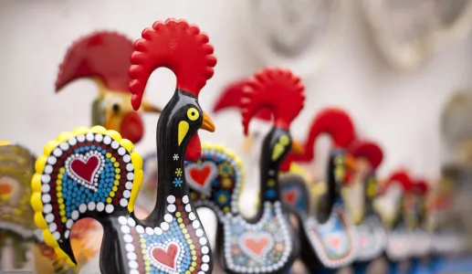 Imagem de várias figuras em barro do galo de Barcelos, numa loja de artigos para turistas.