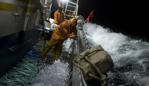 Pescadores indonésios a pescar durante a noite em Portugal, com grandes ondas a bater no barco.. Crédito: Daniel Rodrigues