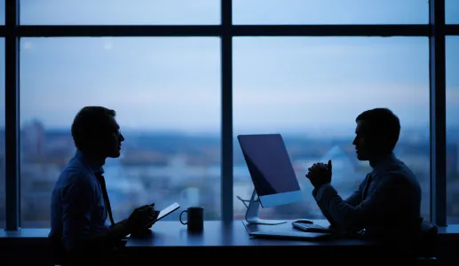 Duas pessoas a trabalhar num escritório. Crédito: Canva