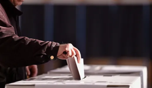 Imagem de um senhor a colocar o voto numa urna