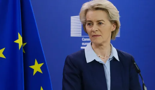 A presidente da Comissão Europeia Ursula von der Leyen a falar, num pulpito, com a bandeira da UE ao fundo.